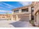A view of the home's exterior showcasing a two-car garage, balcony, and neutral color scheme at 19700 N 76Th St # 2072, Scottsdale, AZ 85255