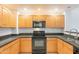 Well-lit kitchen featuring wood cabinets, granite countertops, and black appliances at 19700 N 76Th St # 2072, Scottsdale, AZ 85255