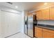 Kitchen view with stainless steel refrigerator, wood cabinets, and closet space with adjacent granite countertops at 19700 N 76Th St # 2072, Scottsdale, AZ 85255