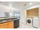 Kitchen area with stainless steel sink, dishwasher, and adjacent laundry closet with washer and dryer at 19700 N 76Th St # 2072, Scottsdale, AZ 85255