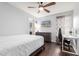 This bedroom features light blue walls, a ceiling fan, an entertainment center, and a work desk at 22415 N 34Th Ln, Phoenix, AZ 85027