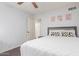 Bright bedroom featuring white walls, a large bed with decorative pillows, and a ceiling fan at 22415 N 34Th Ln, Phoenix, AZ 85027