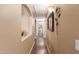 Long hallway featuring beige walls and dark floors leading to a brightly lit room at the end at 22415 N 34Th Ln, Phoenix, AZ 85027