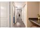 This hallway leads to a laundry area with a tiled floor and beige-colored walls at 22415 N 34Th Ln, Phoenix, AZ 85027