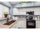 Close up of kitchen featuring granite counters, a stainless steel sink, and a black oven at 22415 N 34Th Ln, Phoenix, AZ 85027