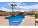 Lush backyard featuring a sparkling swimming pool with rock details, lounge chairs, and mature landscaping at 22415 N 34Th Ln, Phoenix, AZ 85027