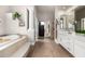 Elegant bathroom featuring double vanities, a soaking tub, and a walk-in shower, designed for relaxation at 22477 S 197Th Cir, Queen Creek, AZ 85142