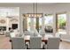 Elegant dining room featuring a modern chandelier and views of the outdoor pool area, perfect for entertaining at 22477 S 197Th Cir, Queen Creek, AZ 85142