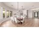 Open concept dining room featuring wood floors, abundant natural light, and modern furnishings at 22477 S 197Th Cir, Queen Creek, AZ 85142
