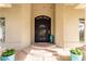Beautiful custom iron front door with decorative accents, framed by stucco walls and potted plants at 22477 S 197Th Cir, Queen Creek, AZ 85142