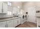 Functional laundry room with ample storage, sink, and updated washer and dryer at 22477 S 197Th Cir, Queen Creek, AZ 85142