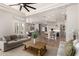 Open-concept living room with neutral furniture, a fireplace, and seamless access to the kitchen at 22477 S 197Th Cir, Queen Creek, AZ 85142