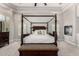 Spacious main bedroom featuring a four-poster bed, tray ceiling, and a charming fireplace for cozy evenings at 22477 S 197Th Cir, Queen Creek, AZ 85142