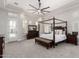 Spacious main bedroom with a four-poster bed, tray ceilings, and ample natural light, offering a serene retreat at 22477 S 197Th Cir, Queen Creek, AZ 85142