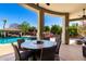 Inviting outdoor patio with comfortable seating, string lights, and views of the sparkling pool and lush backyard at 22477 S 197Th Cir, Queen Creek, AZ 85142