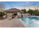 Backyard oasis featuring a sparkling pool, a covered lounge area, and lush landscaping at 22477 S 197Th Cir, Queen Creek, AZ 85142