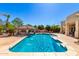 Sparkling pool surrounded by mature trees, lush landscaping, and a covered patio for outdoor entertainment at 22477 S 197Th Cir, Queen Creek, AZ 85142