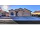 One-story house with tan exterior, two-car garage, and landscaped front yard at 22488 N Mulligan Dr, Maricopa, AZ 85138