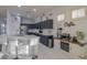 Modern kitchen with dark cabinets, white quartz countertops, and island with seating at 22488 N Mulligan Dr, Maricopa, AZ 85138