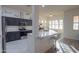 Modern kitchen with dark cabinets, white quartz countertops, and island at 22488 N Mulligan Dr, Maricopa, AZ 85138