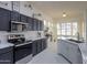 Modern kitchen with dark cabinets, white quartz counters, and stainless steel appliances at 22488 N Mulligan Dr, Maricopa, AZ 85138