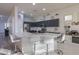 Modern kitchen with dark cabinets, white quartz counters, and island with seating at 22488 N Mulligan Dr, Maricopa, AZ 85138