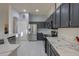 Modern kitchen with dark gray cabinets and white quartz countertops at 22488 N Mulligan Dr, Maricopa, AZ 85138