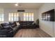 Spacious living room with a large sectional sofa and flat-screen TV at 22488 N Mulligan Dr, Maricopa, AZ 85138