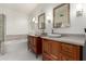 Bathroom with double sinks, wood cabinets, and tile floors at 3037 E Roveen Ave, Phoenix, AZ 85032