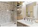 Bright bathroom features a marble-look wall in shower, marble countertop, and shelf with decorations at 31016 N 42Nd Way, Cave Creek, AZ 85331