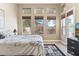 Bright bedroom with multiple windows, wood floors, a decorative rug, and a door to an outdoor seating area at 31016 N 42Nd Way, Cave Creek, AZ 85331