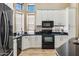 Well-lit kitchen with white cabinetry, black appliances, granite countertops, and bay windows, blending style and functionality at 31016 N 42Nd Way, Cave Creek, AZ 85331