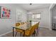 Bright dining room with a modern light fixture, glass table, and comfortable mustard colored chairs at 3132 N 15Th Ave, Phoenix, AZ 85015