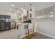 A kitchen featuring white cabinetry, stainless steel appliances, an island with barstool seating, and modern pendant lighting at 3132 N 15Th Ave, Phoenix, AZ 85015