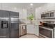 Well-lit kitchen featuring stainless steel appliances, white cabinetry, and a corner sink with a window view at 3132 N 15Th Ave, Phoenix, AZ 85015