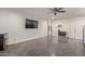 A living room with polished concrete floors, modern decor, a mini fridge, and a large screen television at 3132 N 15Th Ave, Phoenix, AZ 85015