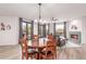 Dining area with wooden table set, fireplace, and natural light from glass doors and windows with patterned curtains at 37327 N 16Th St, Phoenix, AZ 85086