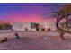 Charming stucco home featuring desert landscaping, accent lighting and a gated entry under a colorful sky at 37327 N 16Th St, Phoenix, AZ 85086