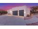 Large two-car garage featuring black doors and a wide driveway plus desert landscaping with pathway at 37327 N 16Th St, Phoenix, AZ 85086