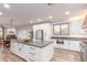 Spacious kitchen with white cabinets, stainless steel appliances, and island with seating, flowing into dining space at 37327 N 16Th St, Phoenix, AZ 85086