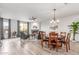 Open-concept living and dining area featuring a fireplace, modern lighting, and wood-style flooring at 37327 N 16Th St, Phoenix, AZ 85086