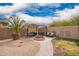 Private backyard with lush palm, fire pit, and covered patio seating for cozy gatherings at 41219 W Brandt Dr, Maricopa, AZ 85138