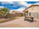 Backyard featuring picnic table and stone walkway leading to gravel and plants at 41219 W Brandt Dr, Maricopa, AZ 85138