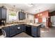 Bright kitchen featuring a large island, stainless steel appliances, and a view to the sitting area at 41219 W Brandt Dr, Maricopa, AZ 85138