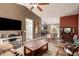 Open-concept living room with neutral-toned sofa, ceiling fan, and view into dining area at 41219 W Brandt Dr, Maricopa, AZ 85138