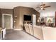 Bright living room with dark accent wall, ceiling fan, and an open floor plan to the kitchen at 41219 W Brandt Dr, Maricopa, AZ 85138