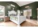 Vaulted ceiling primary bedroom with a white bed frame, dark green walls and cozy decor at 41219 W Brandt Dr, Maricopa, AZ 85138
