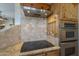 Close-up of a modern kitchen with a cooktop, stainless steel oven, and custom tile backsplash at 4185 S Redtail Trl, Gold Canyon, AZ 85118