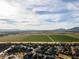 Distant aerial landscape view over houses towards mountains on the horizon and local fields at 44250 W Vineyard St, Maricopa, AZ 85139