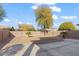 An empty backyard with gravel and concrete accents features a brick fence for added privacy at 44250 W Vineyard St, Maricopa, AZ 85139